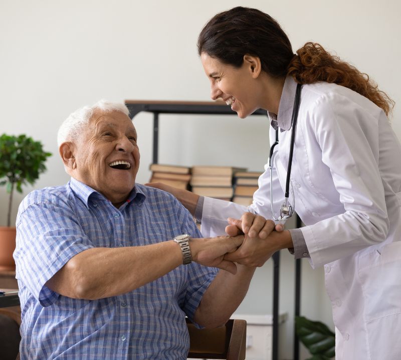 Elderly man sharing a laugh with a caretaker